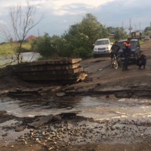 Жителей Канска после ливня переносили через разрытую дорогу в ковше экскаватора